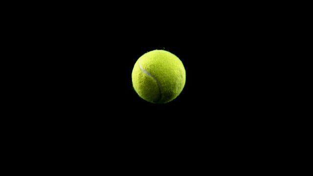 Super slow motion of rotating tennis ball on black background. Filmed on high speed cinema camera, 1000fps.