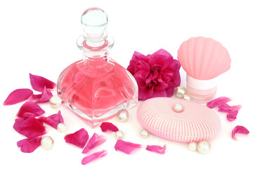 Rose perfume in art deco glass bottle with flower, petals and pearls with soap and moisturiser for...
