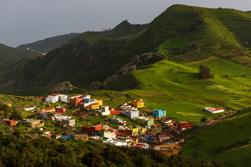 Fototapeta na wymiar The mountain village on the green meadow of a tropical island