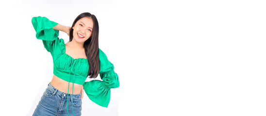 Attractive beautiful positive happy smile asian woman hands point up and pose with empty space wearing green shirt and jeans.