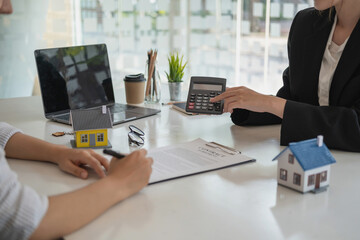 Buying houses and land, guarantees, contract and agreement, An employee of a real estate company hands over the house and keys after the contract for the sale of land and buildings is complete.