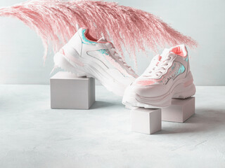 White pastel sneakers with sequins on geometric podiums with pampas - 509567403