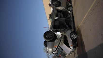 Two wrecked silver cars stacked on top of each other at the junkyard, vertical - Powered by Adobe