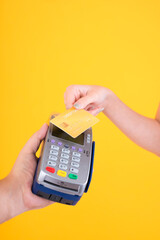 Moment of payment, payment with a credit card through terminal money yellow background,Mobile banking, online shopping Payment by card with the payment terminal.