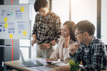 Colleague young employee analyzing marketing research results or sales statistics data at briefing meeting in office. The concept of cooperation of people in the organization of teamwork.