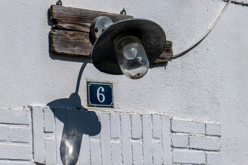 lampadaire au dessus d'une porte avec plaque de numéro 6 