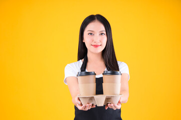 pretty asian female smile wearing black apron show present and poing to coffee paper cup small business and startup