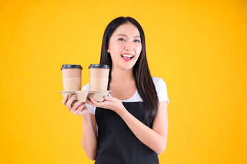 pretty asian female smile wearing black apron show present and poing to coffee paper cup small business and startup