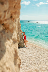 stunning woman in red swimsuit at the sea beach