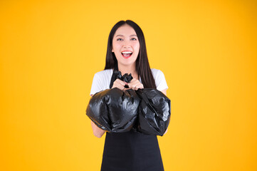 Obraz premium pretty asian female wearing black apron holding black trash bags waste sorting and sustainability concept