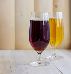 Dark and light beer in glasses on the wooden background