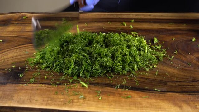 The cook cuts fennel on a board.