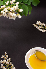 Obraz na płótnie Canvas acacia honey on a black background with acacia flowers