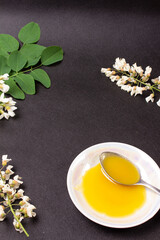 acacia honey on a black background with acacia flowers