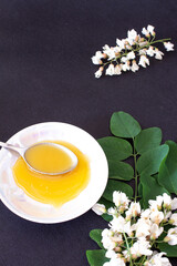 acacia honey on a black background with acacia flowers
