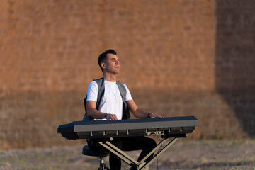 Man plays the piano outdoors