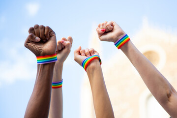 Four fists claiming gay pride rights with gay pride bracelet