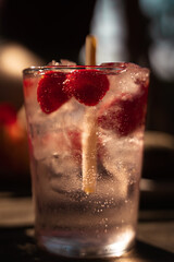 Pink Gin-Tonic cocktail on a terrace in summer close up