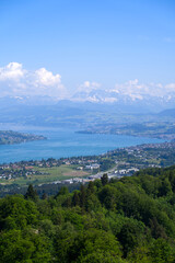 Naklejka na ściany i meble Aerial view of Lake Zürich and Canton Zürich with the Swiss Alps in the background seen from local mountain Uetliberg on a sunny spring day. Photo taken May 18th, 2022, Zurich, Switzerland.