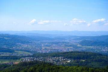 Fototapeta premium Aerial view of midland with agricultural fields, wood and hills seen from local mountain Uetliberg on a sunny spring day. Photo taken May 18th, 2022, Zurich, Switzerland.