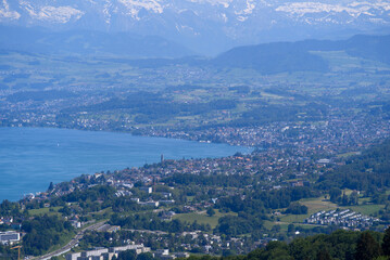 Fototapeta na wymiar Aerial view of Lake Zürich and Canton Zürich with the Swiss Alps in the background seen from local mountain Uetliberg on a sunny spring day. Photo taken May 18th, 2022, Zurich, Switzerland.