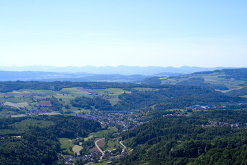 Aerial view of midland with agricultural fields, wood and hills seen from local mountain Uetliberg on a sunny spring day. Photo taken May 18th, 2022, Zurich, Switzerland.