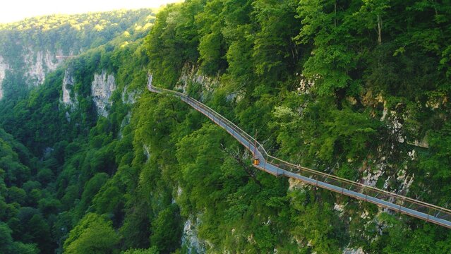aerial shot of an awesome nature - high cliffs with bright green vegetation and a hiking trail on it Okatse Canyon, Imereti region, Georgia. High quality photo