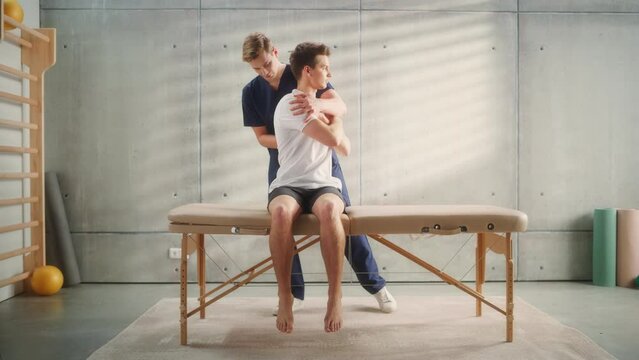 Professional Sport Physiotherapist Working on Specific Muscle Groups and Back Pain with Young Male Athlete. Sportsman Recovering from Mild Injury. Trauma Prevention Therapy or Rehabilitation.