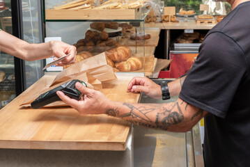 payment with the card for a purchase in the bakery store - retail sales concept