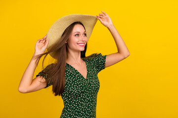 Portrait of cheerful nice person hands touch sunhat beaming smile look empty space isolated on yellow color background