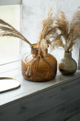 two glass vases are on the windowsill