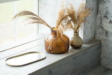 two glass vases are on the windowsill