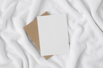 Blank paper on white terry towel with copy space. Paper mockup for postcard or advertisement.