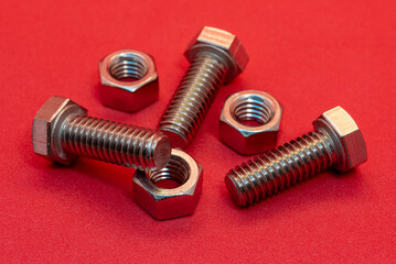 Bolts and nuts on a red background