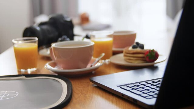 food blogging concept - pancakes, coffee, orange juice and camera on kitchen table at home