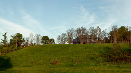 Obraz premium grassy hill with a wooden house on top 