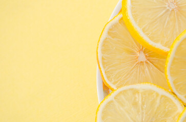 lemon slices on a plate close-up, yellow background.