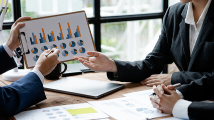 A group of people pointing to papers on a table in a conference room, a financial analyst attending a company audit meeting with the finance and accounting department. Meeting concept.