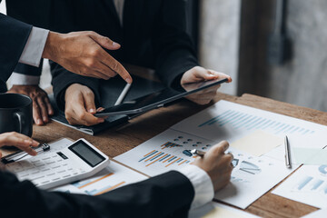 Company meeting room has businessmen and finance managers meeting together on finance topics, they are looking at information on documents and discussing together. Concept company financial management