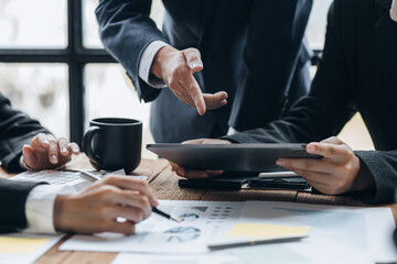 Company meeting room has businessmen and finance managers meeting together on finance topics, they are looking at information on documents and discussing together. Concept company financial management
