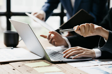 Company meeting room has businessmen and finance managers meeting together on finance topics, they are looking at information on documents and discussing together. Concept company financial management