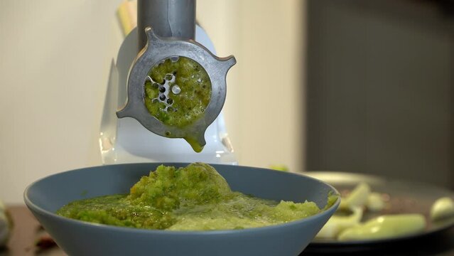 Meat grinder grinds fresh bell pepper in kitchen. Lecho. Preparation of pickles, canned vegetables