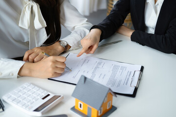 Guarantee, mortgage, agreement, contract, signed, real estate agent pointing to documents for customers to read the agreement before signing important documents