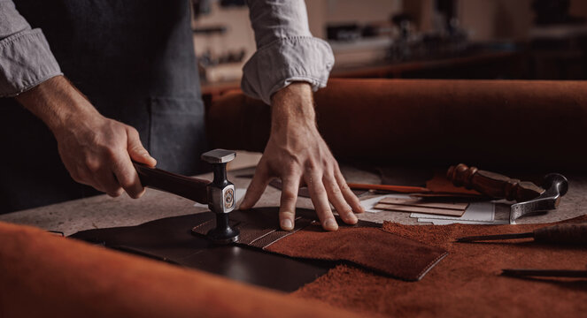 Tailor processing hammers seam on leather goods, Handmade craftsman