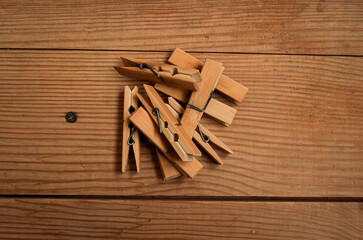 a bunch of wooden clothespins lies on a wooden background top view