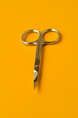iron tool manicure scissors close-up on a bright yellow background