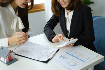 Guarantee, mortgage, contract, contract, signed, real estate agent or bank officer holding a calculator, submits a bid with a customer to buy a home before signing to make a deal