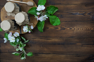 Cans with craft lids stand on a sawn tree on a wooden table