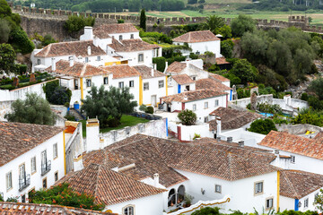 White houses with terracotta roof tiles in tourist village Obidos