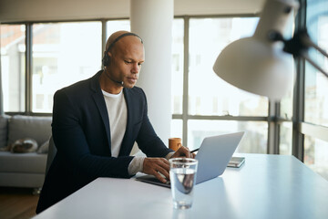 Young African American entrepreneur works on computer in the office.